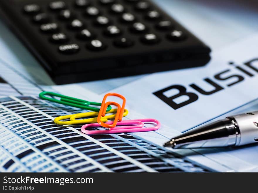 Four Paperclips Next to Silver Ink Pen and Black Calculator