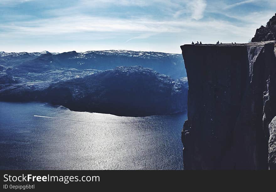 Observation deck on cliff over blue waters of alpine lake on sunny day. Observation deck on cliff over blue waters of alpine lake on sunny day.