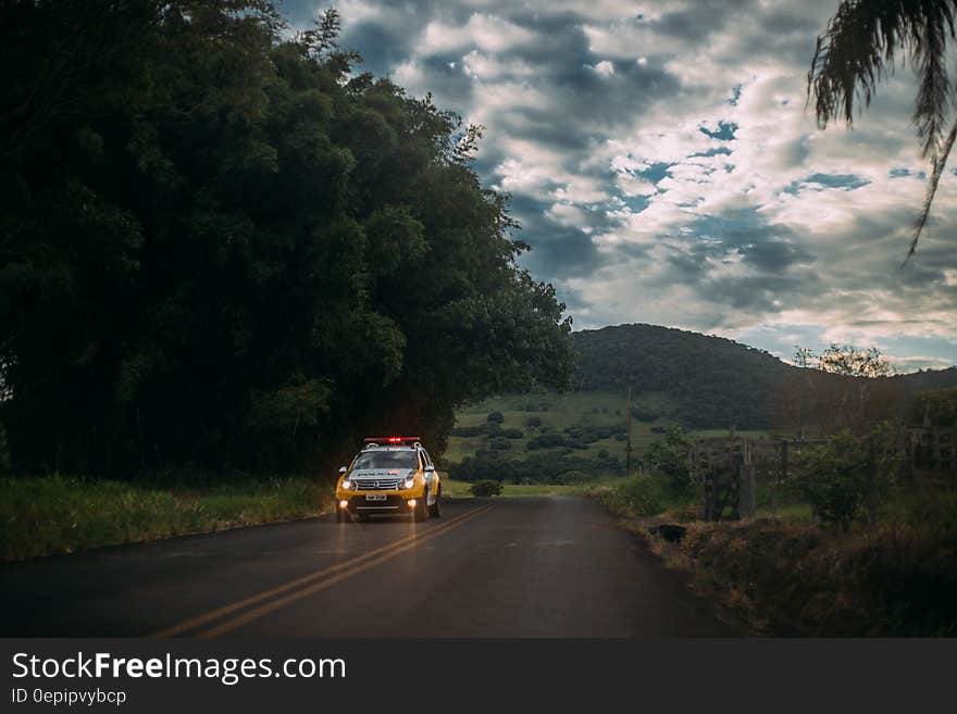 Yellow and White Police Car Lone on the Road