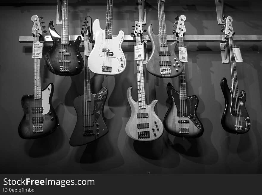 8 Electric Guitars Hanged on Brown Steel Bar