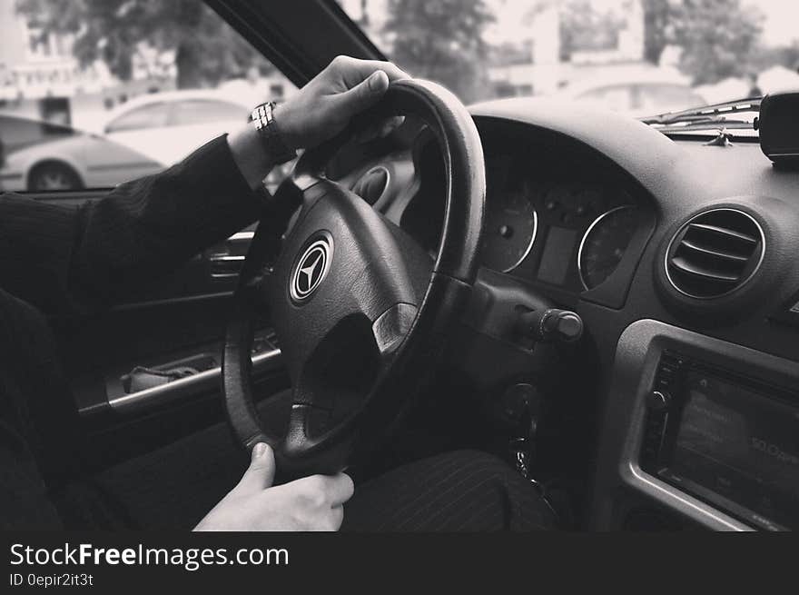 Close up of hands on Mercedes Benz car interior in black and white. Close up of hands on Mercedes Benz car interior in black and white.