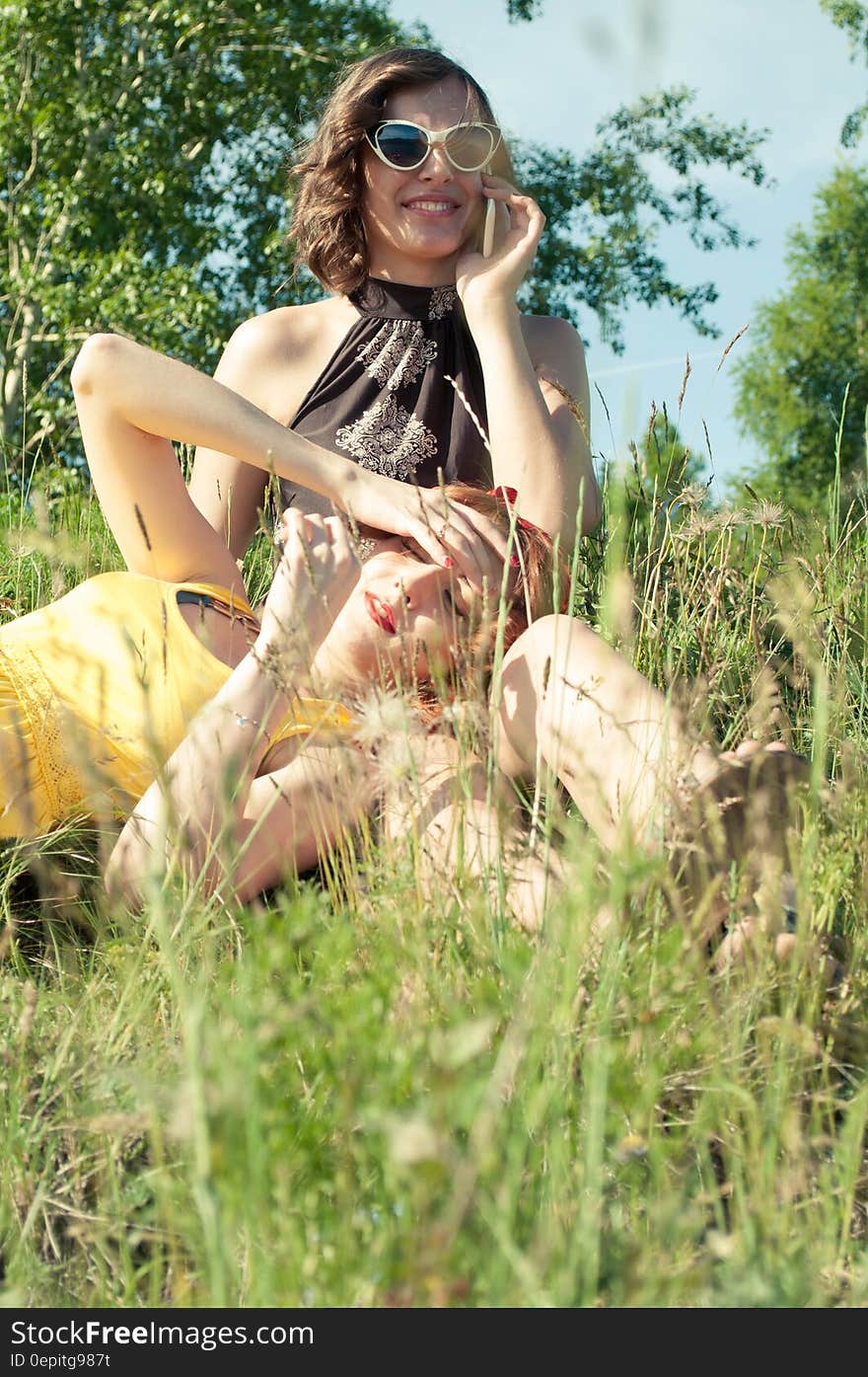 Two Woman on Green Grass during Day Time