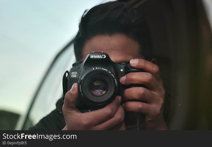 Portrait of photographer behind professional Canon camera. Portrait of photographer behind professional Canon camera.