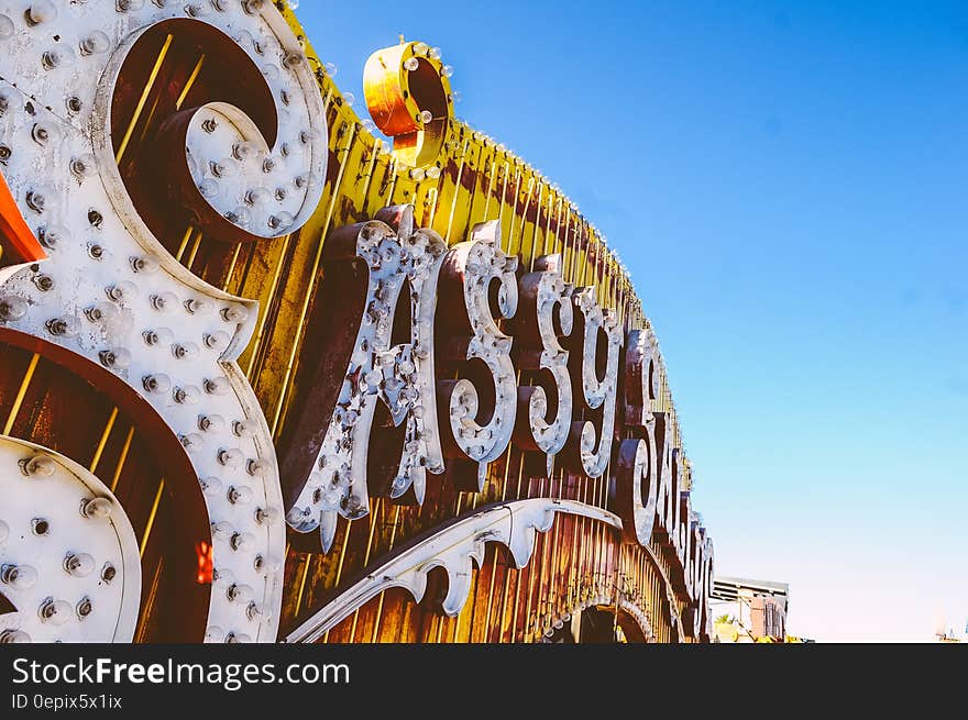 Neon Sassy Saloon sign against blue skies on sunny day.