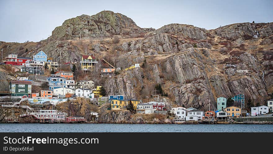 Colorful houses on rocky hillside along waterfront of St. John's, Newfoundland, Canada on sunny day. Colorful houses on rocky hillside along waterfront of St. John's, Newfoundland, Canada on sunny day.