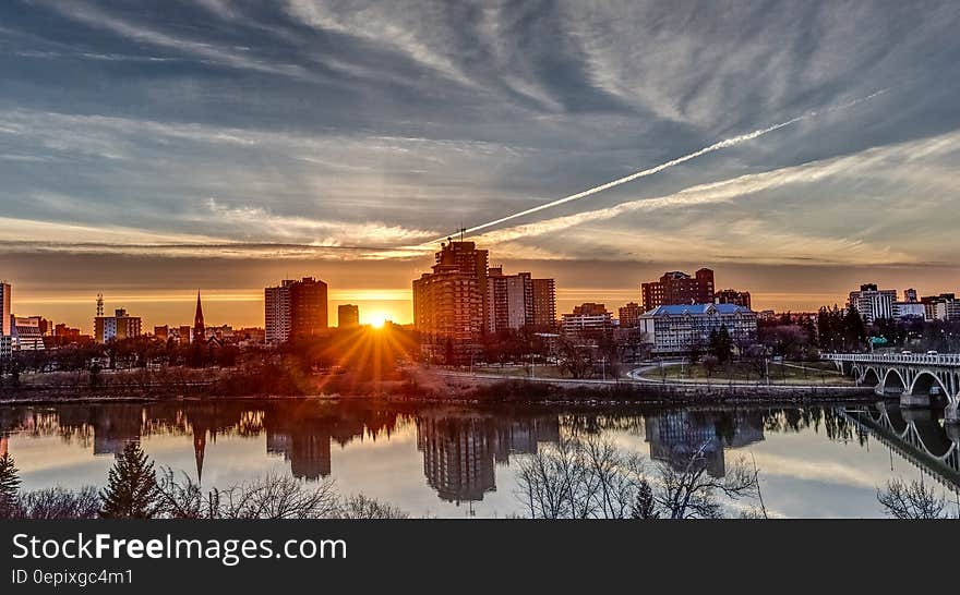 City skyline reflecting in waterfront against blue skies at sunset. City skyline reflecting in waterfront against blue skies at sunset.