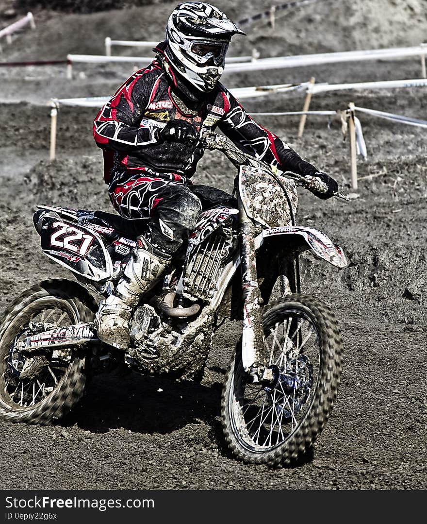 Person Riding on Motorcycle on Motocross Race Track Wearing White and Black Oakley Full Face Helmet during Daytime