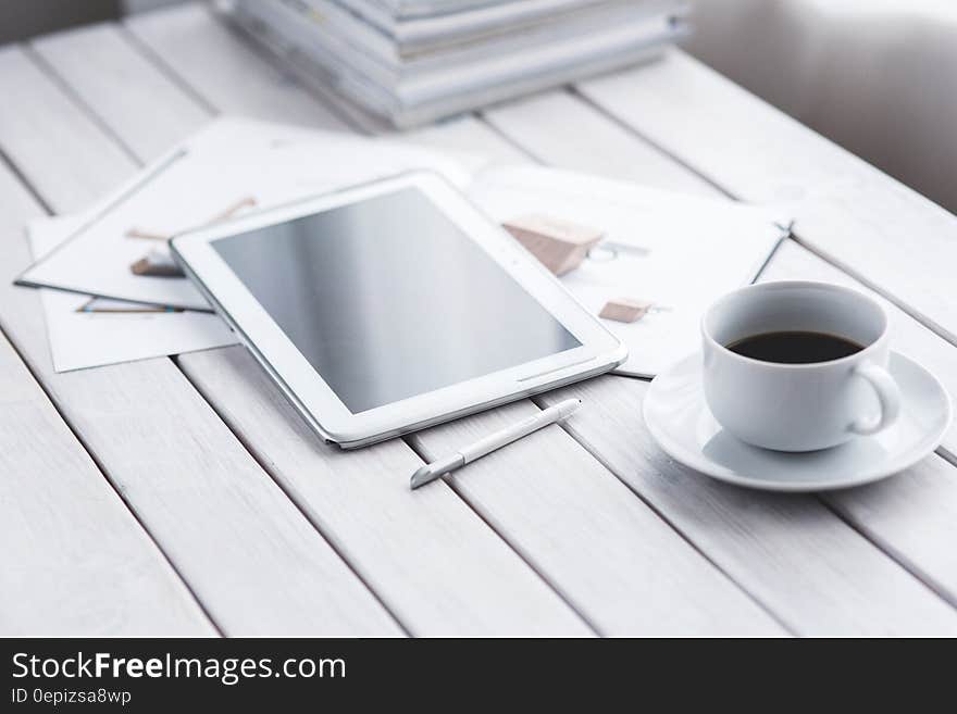 White tablet and cup of coffee