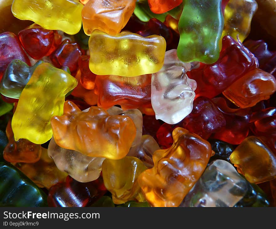 Colorful jelly baby type sweets with some identifiable as having the shape of a bear producing a colorful textured background in green, red, orange, yellow and white. Colorful jelly baby type sweets with some identifiable as having the shape of a bear producing a colorful textured background in green, red, orange, yellow and white.