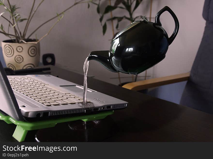 White Kettle Droping Water on Silver Laptop Computer