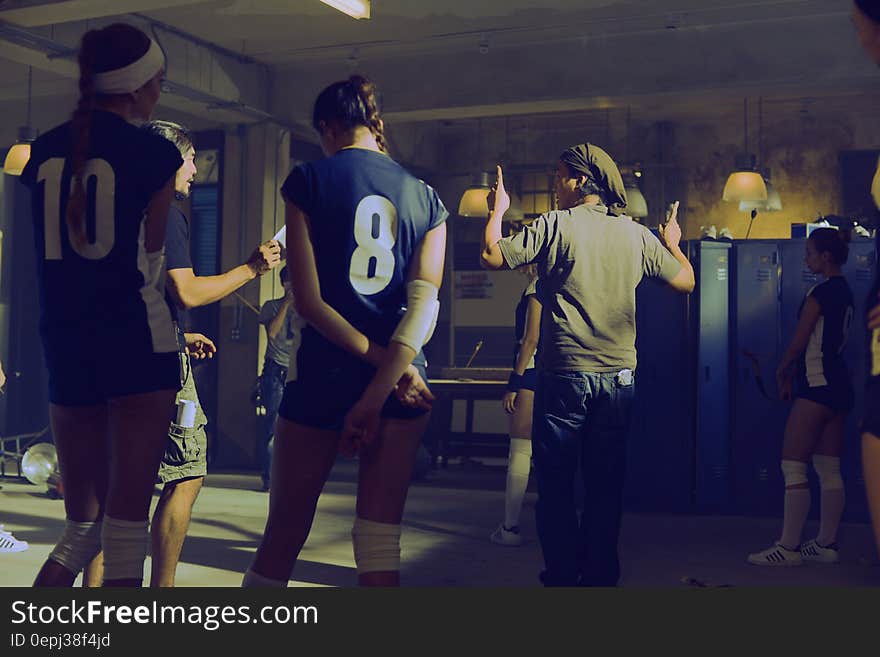 Indoor meeting in locker room of teens wearing numbered jerseys. Indoor meeting in locker room of teens wearing numbered jerseys.