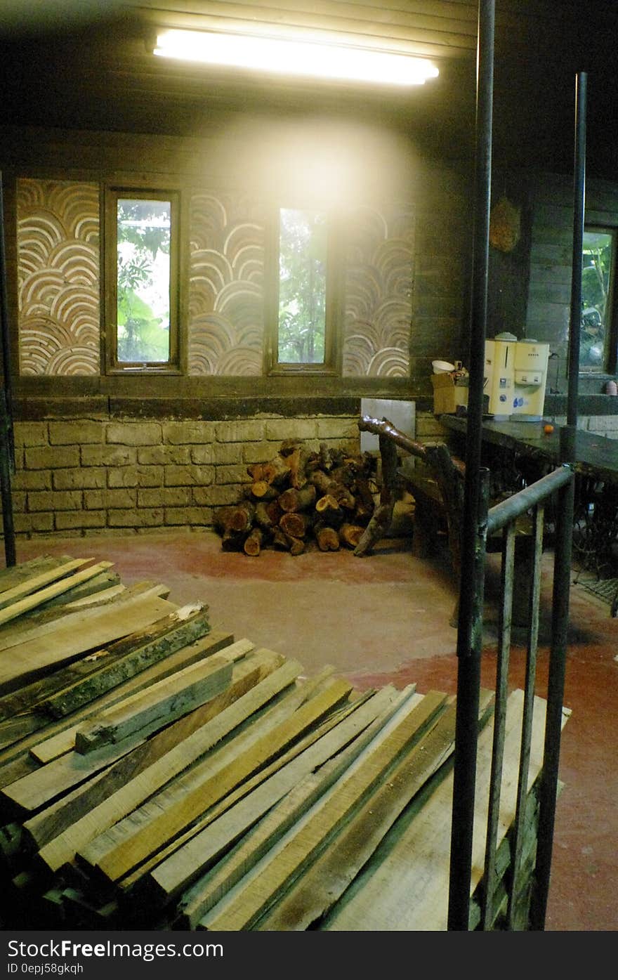 Stack of building lumber and pile of firewood inside room. Stack of building lumber and pile of firewood inside room.