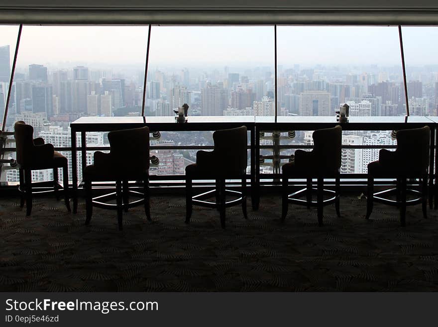 Empty conference or restaurant table and chairs against windows overlooking city skyline from modern skyscraper. Empty conference or restaurant table and chairs against windows overlooking city skyline from modern skyscraper.