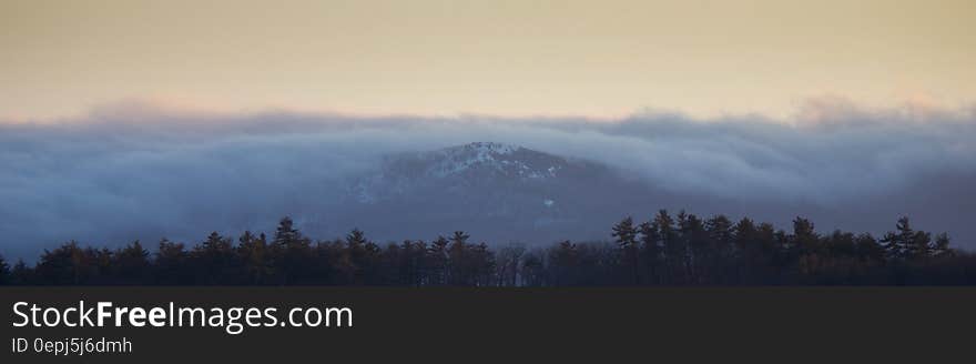 Panorama of mist over mountains with valley forest.