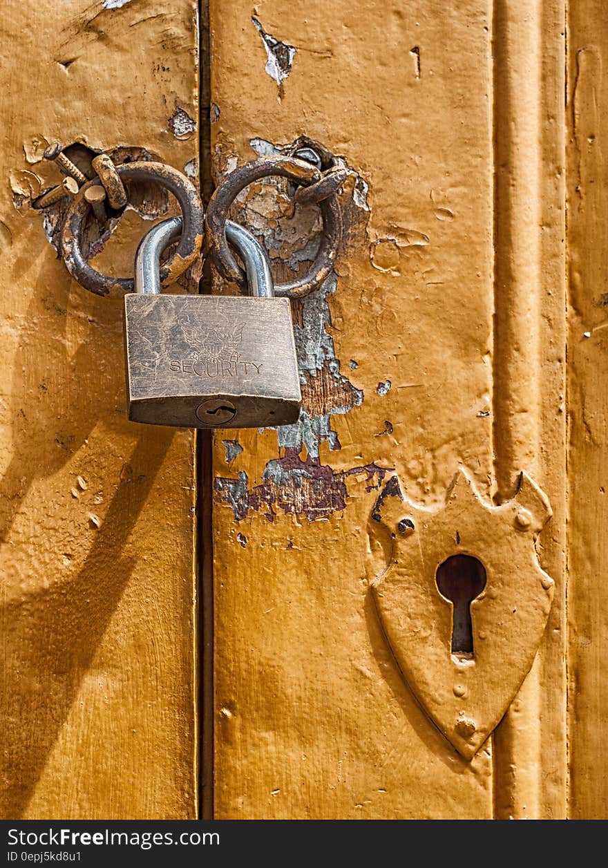 Padlock holding chains closed on old metal door. Padlock holding chains closed on old metal door.