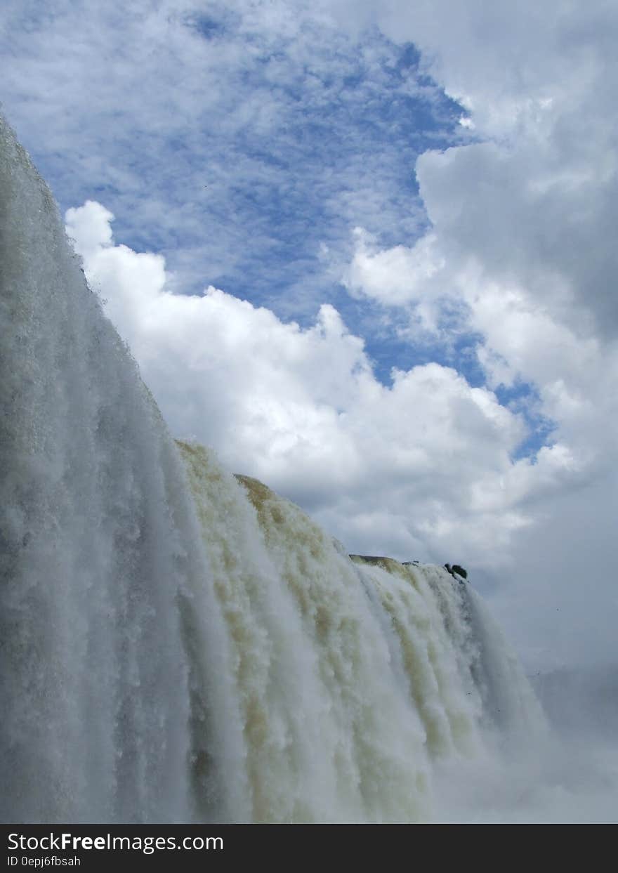 Waterfalls Under Blue Sky With White Clouds during Daytime