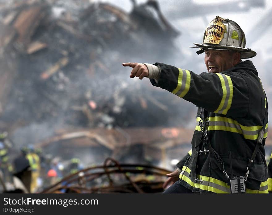 Fire Fighter Wearing Black and Yellow Uniform Pointing for Something