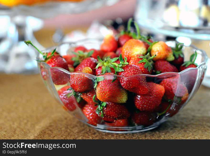 Red Strawberries in Clear Glass Bowl on Brown and Gray Textile