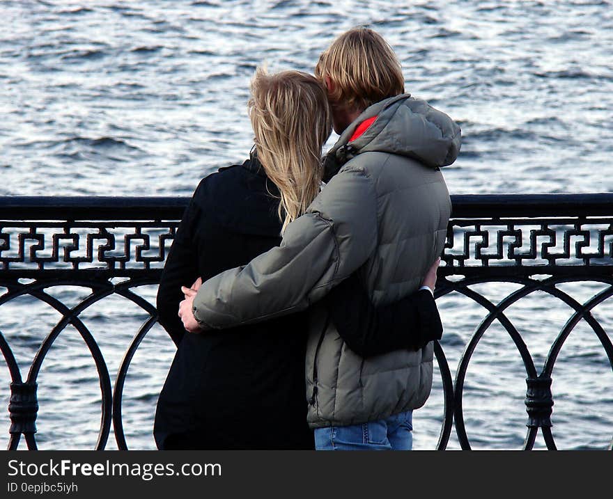 Man in Grey Bubble Jacket Beside Woman in Black Sweater