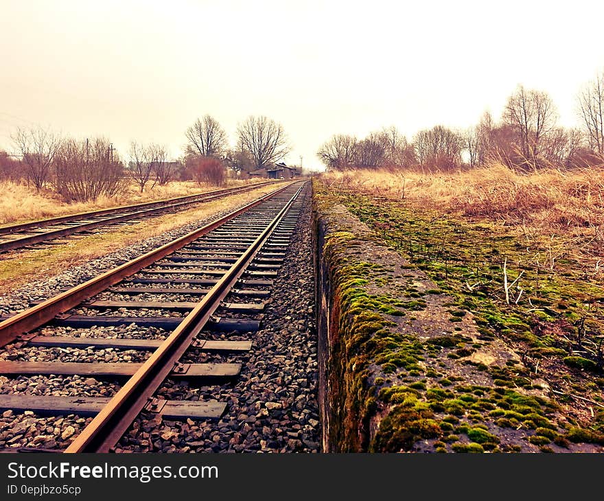 Railway Next to a Grassy Field during Day Time