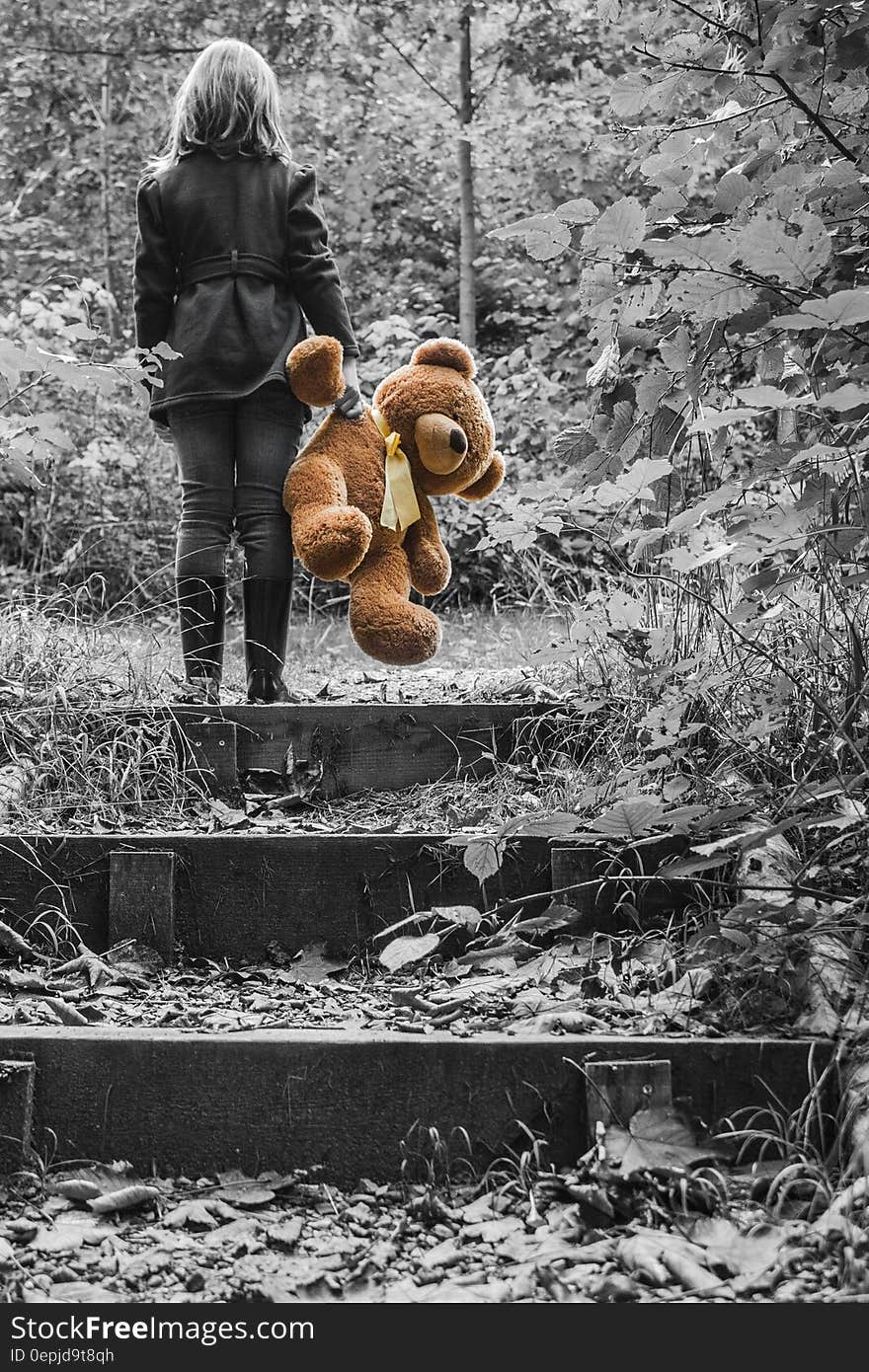 Girl in Jacket Carrying Brown Bear Plush Toy Selective Color Photo