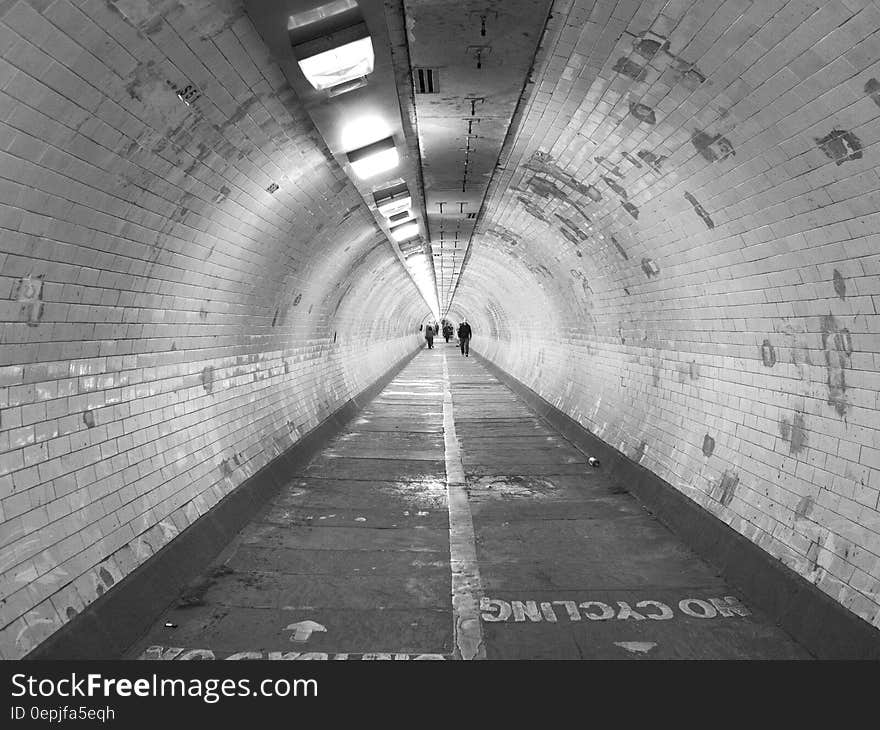 Silhouette of people walking through urban tunnel. Silhouette of people walking through urban tunnel.