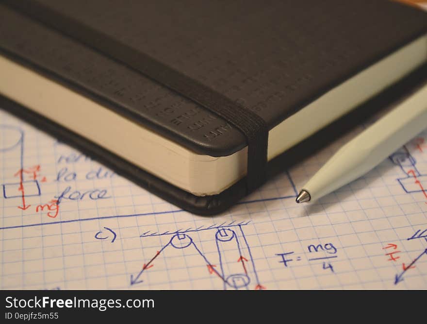 Leather book on page of diagrams and calculations with pen. Leather book on page of diagrams and calculations with pen.