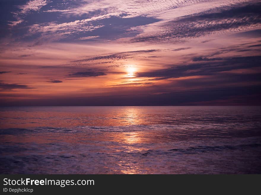 Sunset over waves on ocean waters.