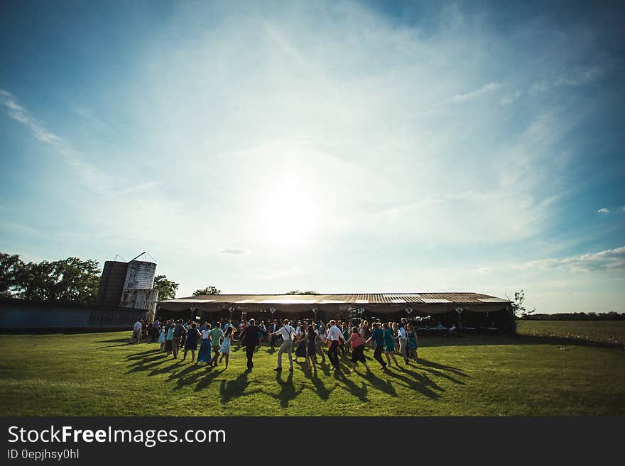 People on the Lawn Grass Running to the House during Daytime