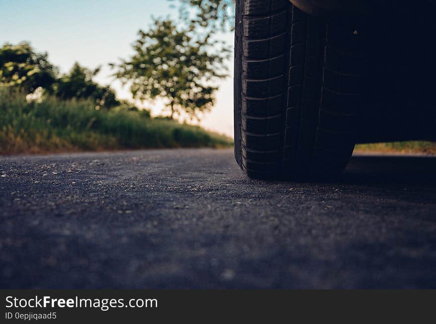 A close up of a car tire on an asphalt road. A close up of a car tire on an asphalt road.