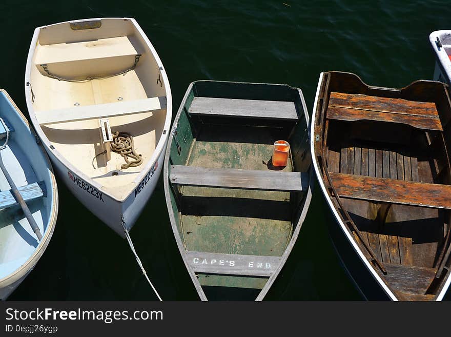 Some rowboats moored on a dock in water. Some rowboats moored on a dock in water.