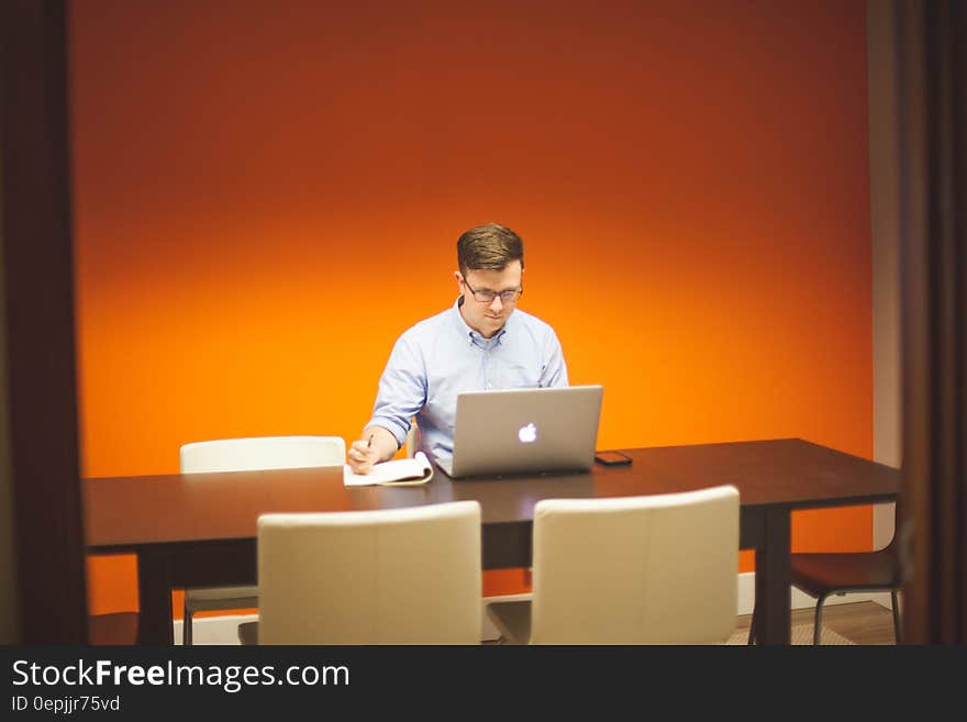 A man using a laptop computer on a desk. A man using a laptop computer on a desk.