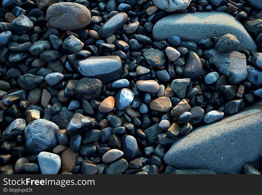 Close up of various pebbles on sunny day.