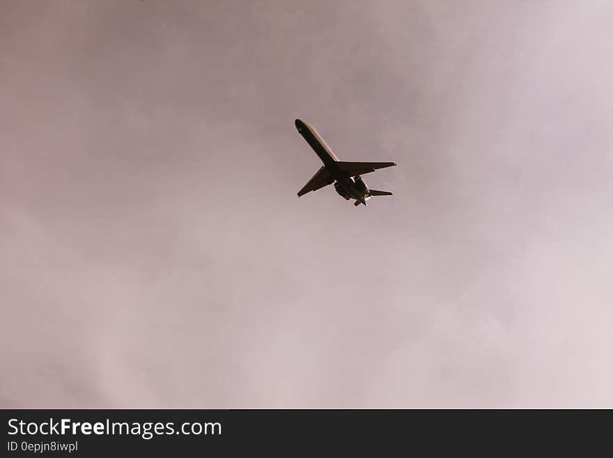 Airplane Flying in Mid Air Under Gray Clouds