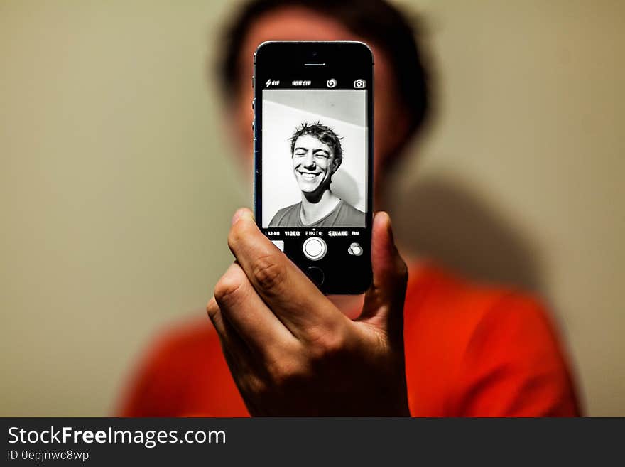 Man in Red Shirt Having Selfie on His Iphone in Grayscale Mode