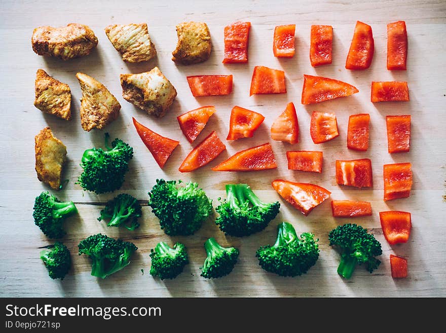 Array of pieces of red sweet bell peppers, broccoli and grilled meats on wood. Array of pieces of red sweet bell peppers, broccoli and grilled meats on wood.