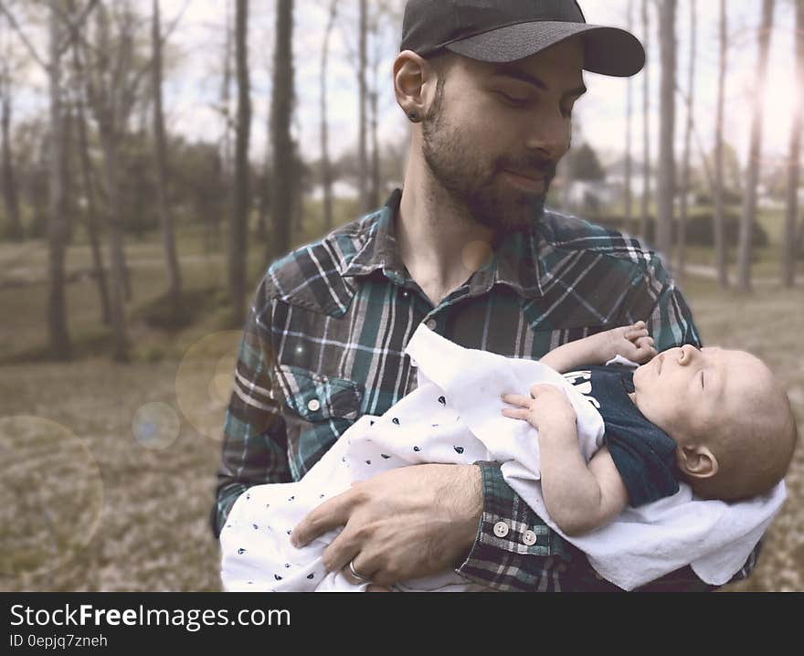 Man Holding Baby during Daytime