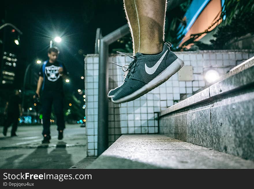 Man in Black White Nike Shoes during Nighttime