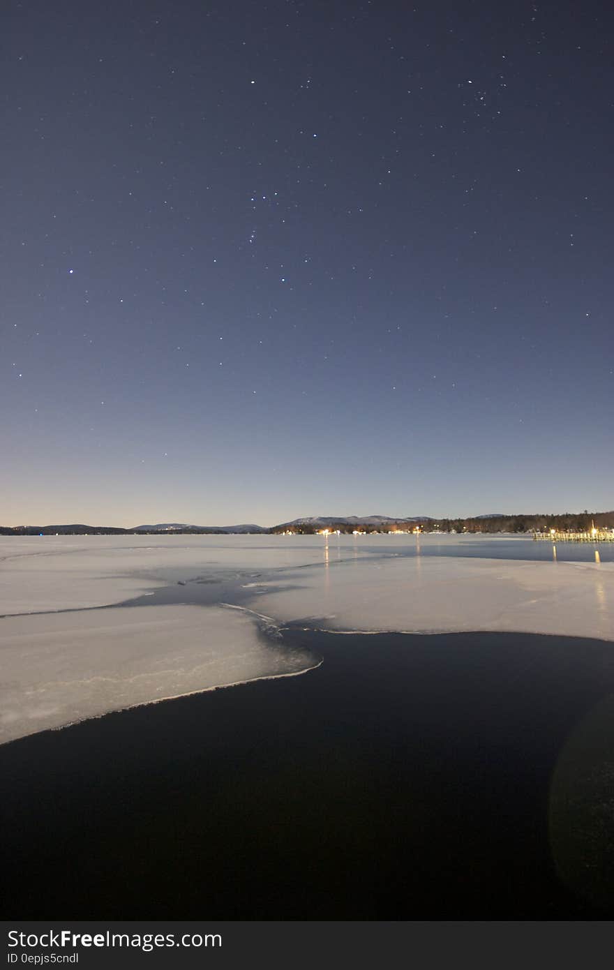 Scenic view of waves on beach at night under starry sky. Scenic view of waves on beach at night under starry sky.