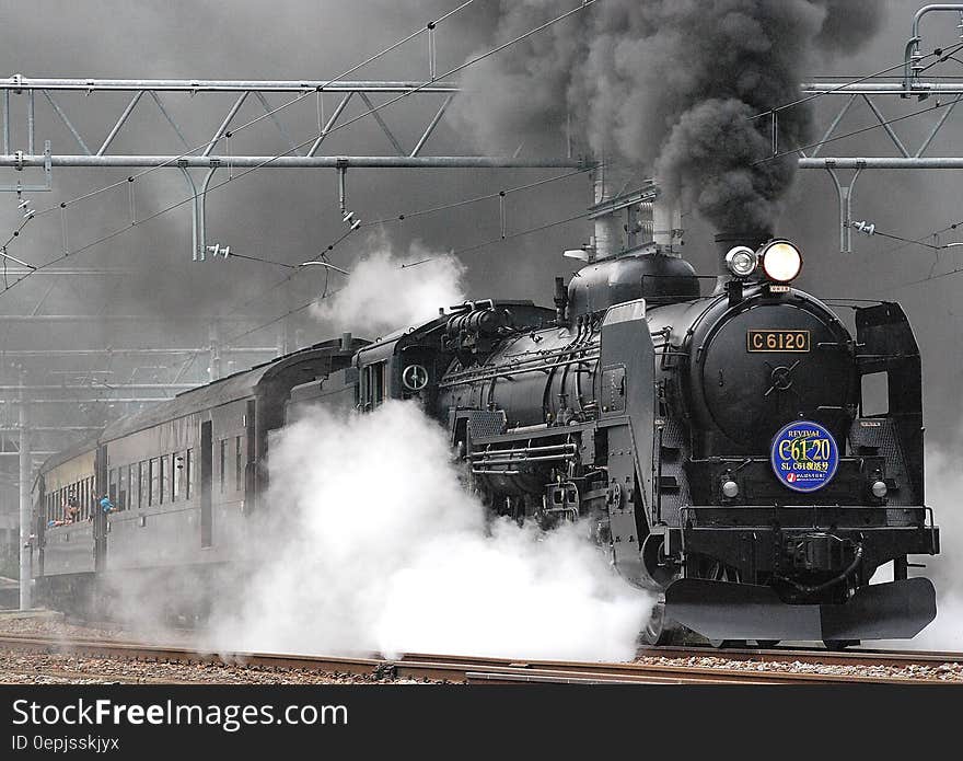 Black Train on Rail and Showing Smoke