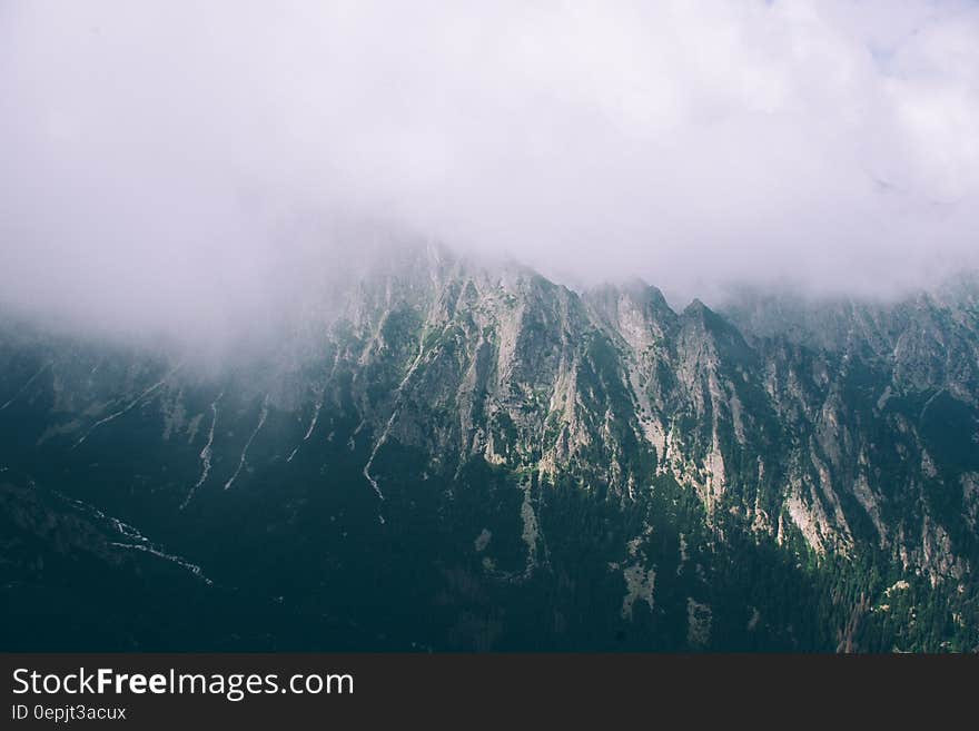 A mountain range with mist or clouds hanging over. A mountain range with mist or clouds hanging over.