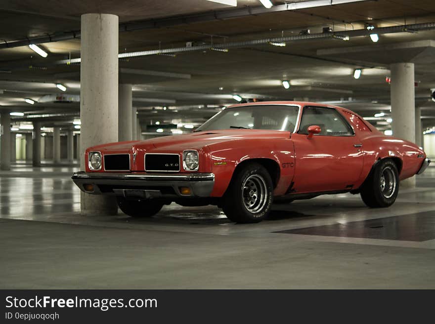 Orange muscle car parked in underground garage. Orange muscle car parked in underground garage.