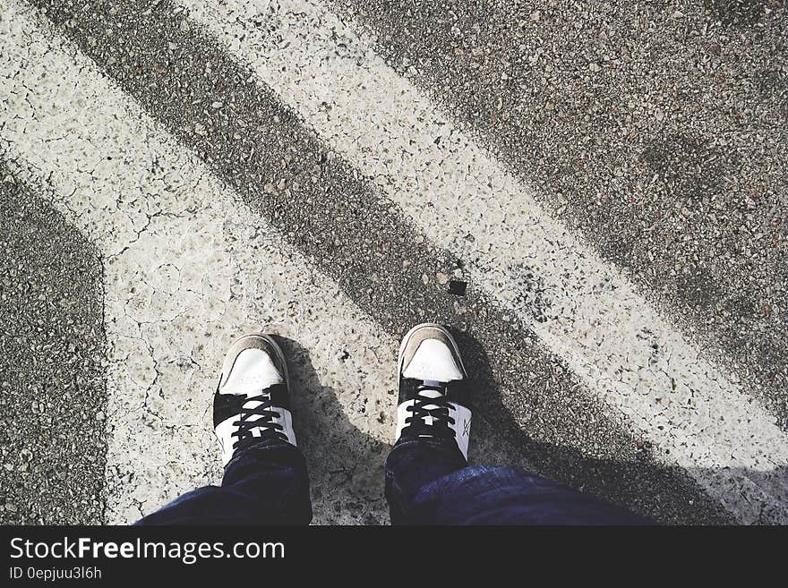 Man in White and Black Sneakers Standing Outdoor during Daytime