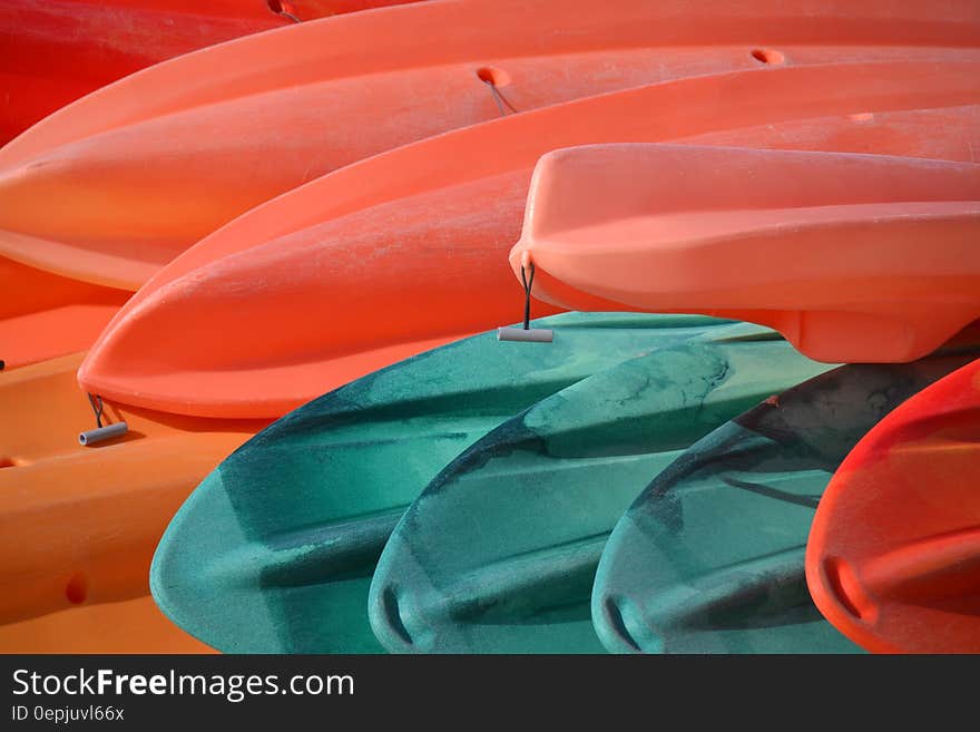 Red and blue plastic canoes stacked outdoors. Red and blue plastic canoes stacked outdoors.