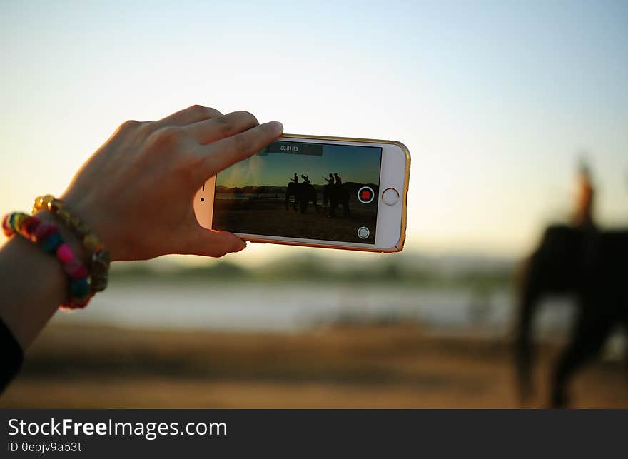 Hand of woman taking video of person riding elephant with smartphone. Hand of woman taking video of person riding elephant with smartphone