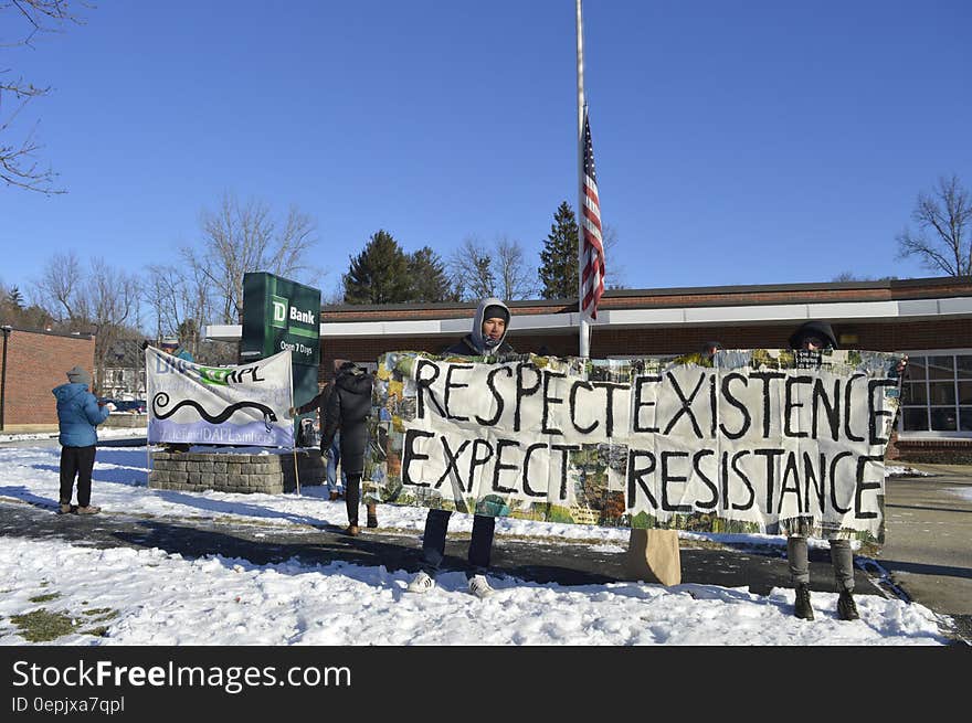 Protesters with sign reading respect existence, expect resistance outside bank building in Standing Rock, North Dakota. Protesters with sign reading respect existence, expect resistance outside bank building in Standing Rock, North Dakota.