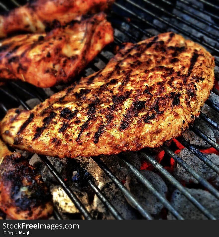 Close up of meat on metal grate over hot coals in barbecue. Close up of meat on metal grate over hot coals in barbecue.