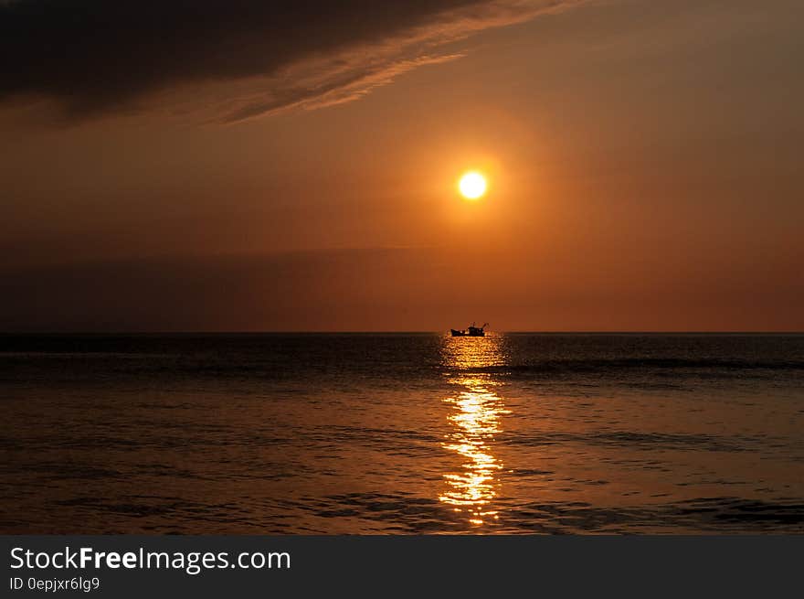 Sunset reflecting in water with boat. Sunset reflecting in water with boat.