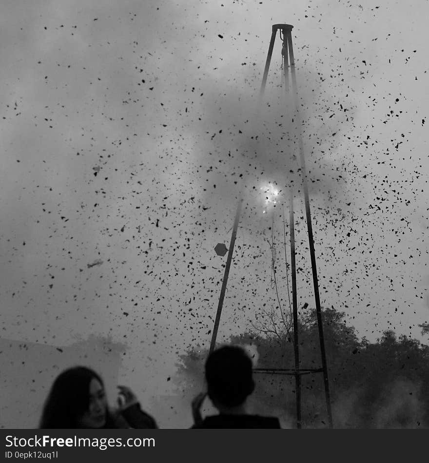 Greyscale Photography of Man and Woman Standing Near Tower