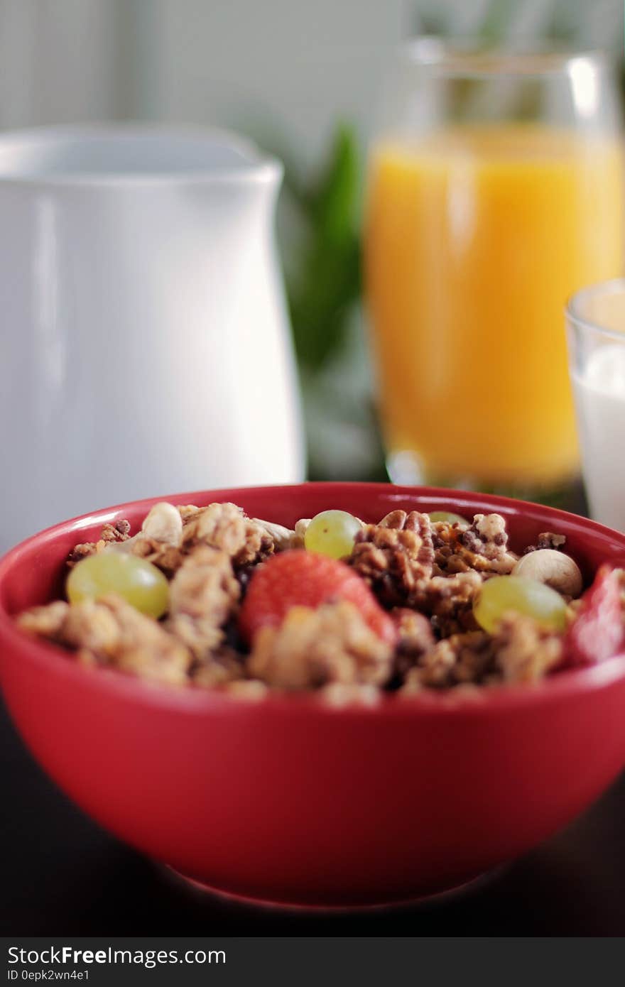 Healthy breakfast with bowl of muesli and glass of fresh orange juice in background. Healthy breakfast with bowl of muesli and glass of fresh orange juice in background.